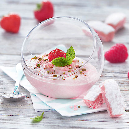 Dessert rose à la framboise en verrine avec menthe, pistaches et cubes de biscuit