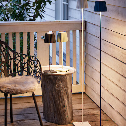 Outdoor Stehlampen in zwei verschiedenen Größen und Farben auf einer Terrasse.