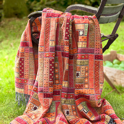 Rote Plaid mit Mustern auf einem Gartenstuhl