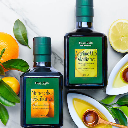 Différantes bouteilles d’huile avec des oranges et des citrons en arrière-plan