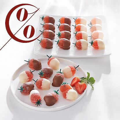 Des fraises trempées dans du chocolat sur une assiette blanche.