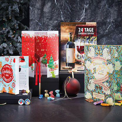 Un large choix de calendriers de l'Avent avec un sapin de Noël en toile de fond