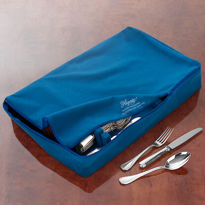 Couverts en argent soigneusement rangés dans une pochette en tissu bleu