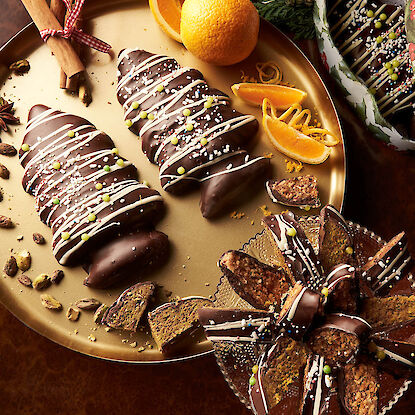 Gâteau sicilien aux amandes et à l'orange en forme de sapin de Noël sur une assiette dorée.