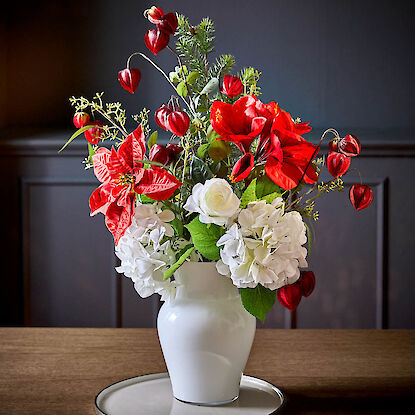 Weihnachtliches Blumengesteck mit Amaryllis, Hortensien und Christrosen in weißer Vase