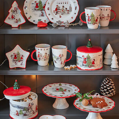 Weihnachtliches Geschirr-Set mit Tellern, Tassen und Dosen im nostalgischen Motiv, dekoriert im Regal