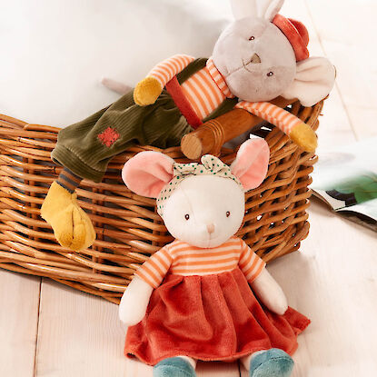 Plüschmäuse als Kuscheltiere, eine im Kleid, eine in Hose, liegend an einem Korb auf Holzboden