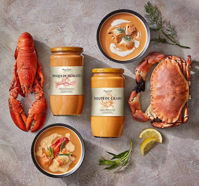 Gläser mit Hummer- und Krabbensuppe, dazu frischer Hummer, Krabbe und Zitronenscheiben