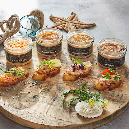 Edle Fischrillettes in Gläsern mit Baguettescheiben, serviert auf Holzbrett mit Meeresdeko