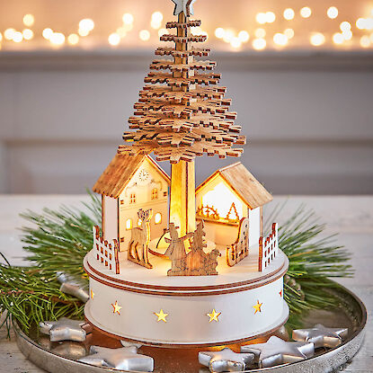 Beleuchtetes Holz-Weihnachtsdorf mit Tannenbaum und Stern auf Dekotablett