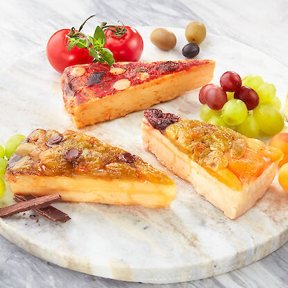 Spanischer Käse in drei Sorten mit Früchten und Nüssen – serviert auf Marmorplatte mit Trauben und Oliven