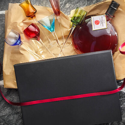 Geschenkset mit bunten Likörgläsern und Flasche Likör in edler Verpackung – stilvolles Präsent für Genießer