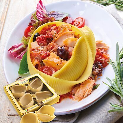 Gefüllte Caccavelle di Napoli mit Tomatensauce, Lachs und Oliven auf weißem Teller angerichtet.