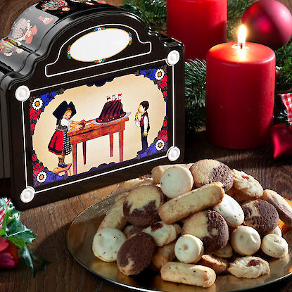 Nostalgische Gebäckdose mit weihnachtlichem Motiv und Plätzchen auf goldener Platte.