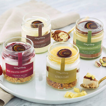 Vier Gläser Dessert im Glas mit Cheesecake, Tiramisu, Lemon Tart und Pistaziencreme.