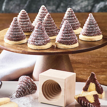 Weihnachtliche Tannenbaum-Plätzchen aus Mürbeteig und Schokolade – festlich präsentiert auf Holzplatte mit Backform