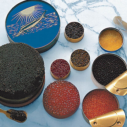 Auswahl feinster Kaviar-Sorten in geöffneten Dosen auf Marmorplatte – luxuriöse Feinkost-Delikatesse