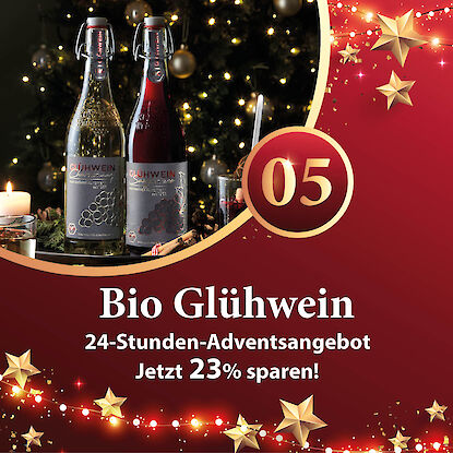 Werbebanner mit zwei Bio-Glühweinflaschen und einem Glas Gewürzglühwein vor Weihnachtsbaum, Hinweis auf 23 % Rabatt.