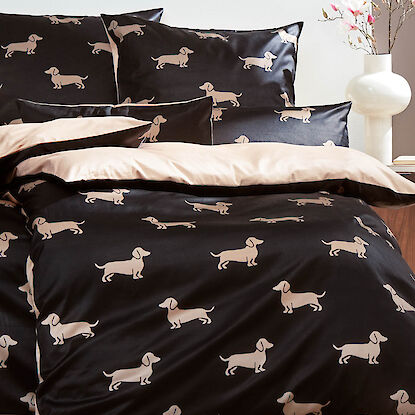 Bettw&auml;sche in Schwarz mit buntem Blumenmuster, dekoriert mit passender Vase und Tischlampe