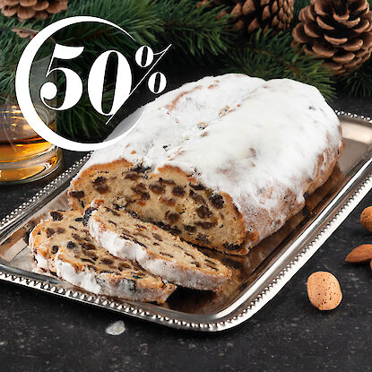 Stollen au whisky entam&eacute; sur un plateau en argent, accompagn&eacute; d&rsquo;un verre de whisky et d&rsquo;amandes.