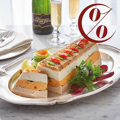 Mehrlagige Fischterrine auf Silberplatte mit Gem&uuml;se-Deko und Salat, daneben Scheibe angeschnitten, Rabattzeichen eingeblendet.