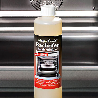Flasche Hagen Grote Backofen-Kraftreiniger steht im ge&ouml;ffneten Backofen, geeignet zum selbstt&auml;tigen Entfernen eingebrannter Fette.