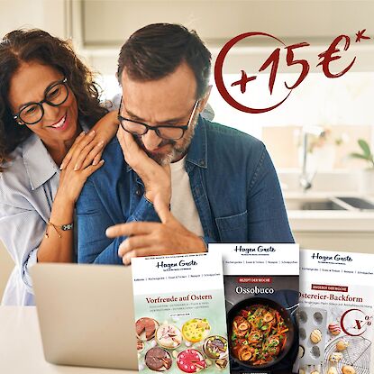 Paar am Laptop mit Hagen Grote Prospekten und 15 &euro; Gutschein-Aktion im Hintergrund